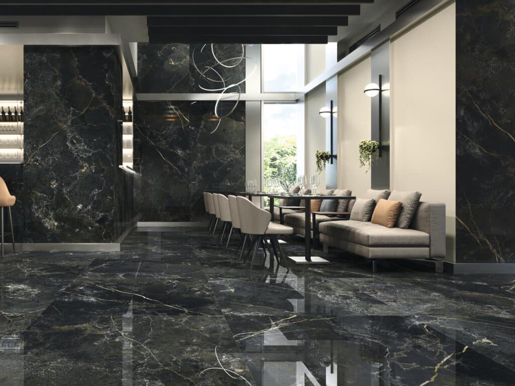Restaurant moderne avec sol et murs en marbre noir poli veiné d'or. Ambiance luxueuse, bar visible, table de repas et éclairage design.