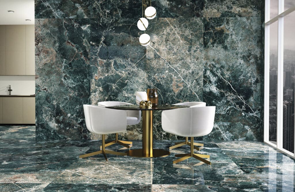 Salle à manger moderne luxueuse avec murs et sol en marbre vert foncé veiné blanc, mobilier blanc et table ronde à pied or.