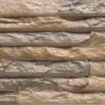 Texture murale effet pierre empilée, pierres rectangulaires et rugueuses aux tons brun clair et gris beige, aspect rustique.