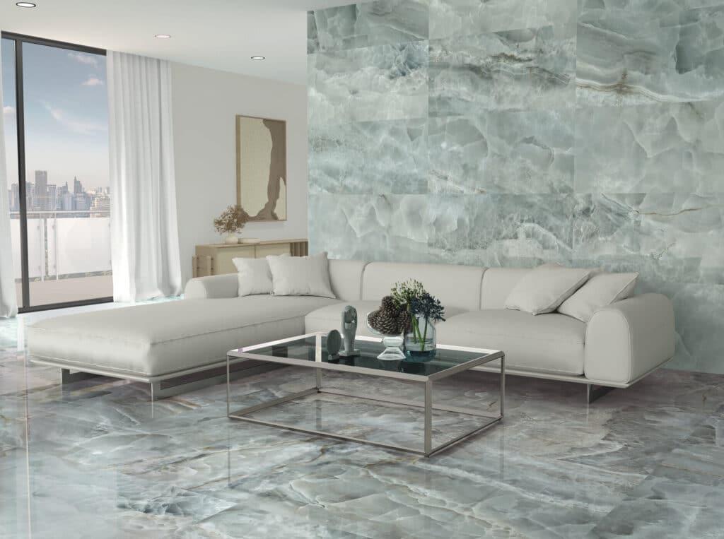 Salon moderne avec canapé blanc, table basse en verre, et revêtement mural et sol en dalles effet onyx bleu-vert poli.