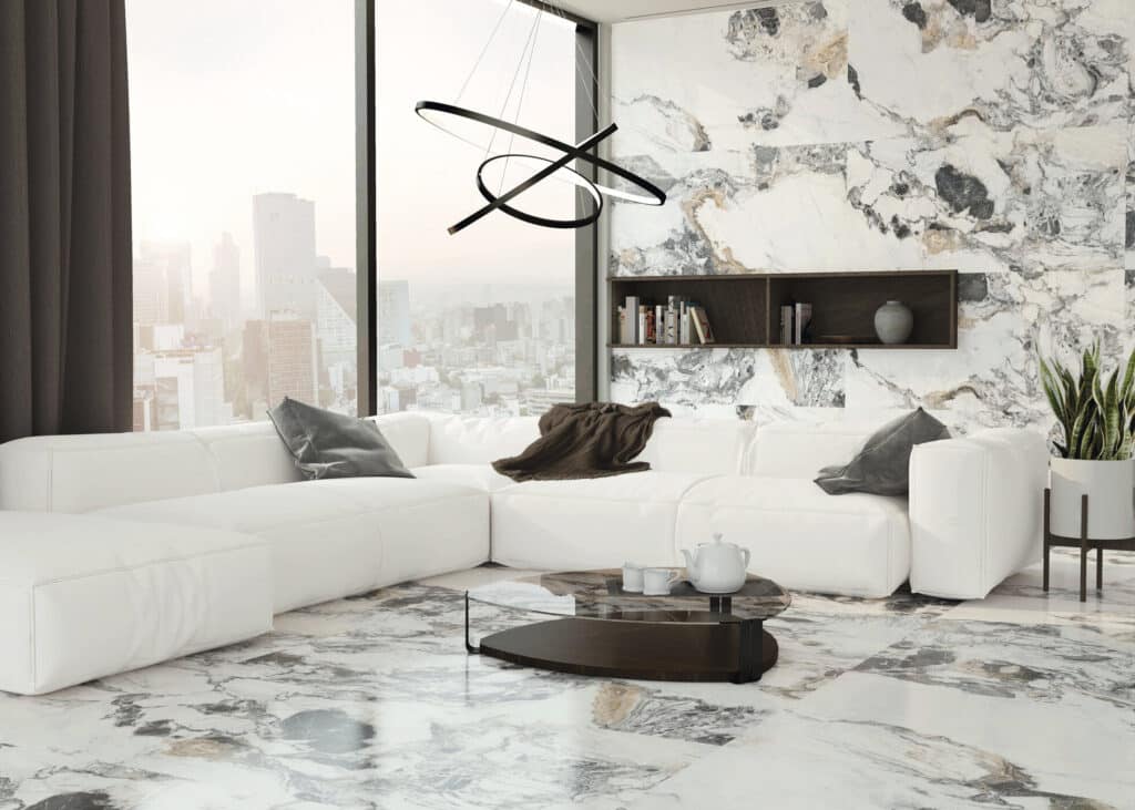 Salon moderne avec canapé blanc, plancher et mur en marbre blanc et noir, suspension luminaire design, vue urbaine brumeuse.